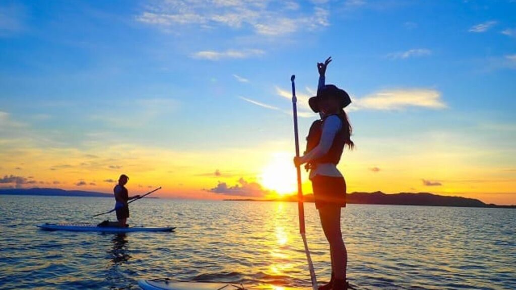 沖縄の海でカップルがサンセットサップしている写真